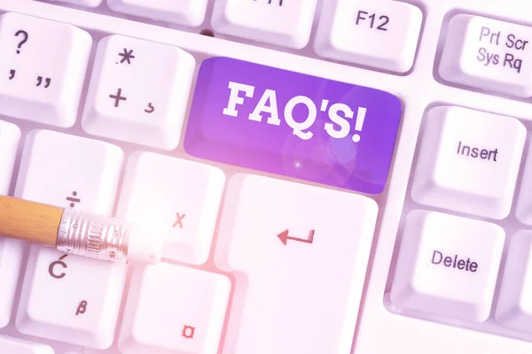 Konceptuell handstil som visar Faq. Business foto text en lista med frågor och svar som rör ett visst ämne Vit dator tangentbord med anteckning papper ovanför den vita bakgrunden. — Stockfoto