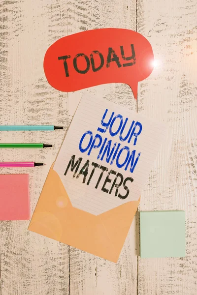 Writing note showing Your Opinion Matters. Business photo showcasing to Have your say Providing a Valuable Input to Improve Envelop speech bubble paper sheet ballpoints notepads wooden background.
