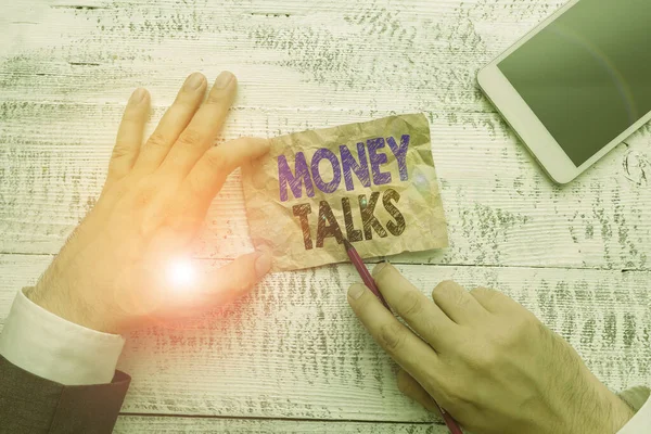 Conceptueel handschrift met Money Talks. Zakelijke foto presentatie van de rijkdom geeft macht en invloed aan degenen die het bezitten Hand houden nota papier in de buurt van het schrijven van apparatuur en smartphone. — Stockfoto