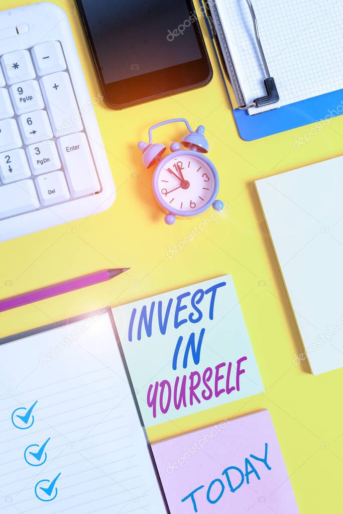 Writing note showing Invest In Yourself. Business photo showcasing Improve your Skills take courses Do masters Scholarship White paper with copy space with paper clips clock and pc keyboard.