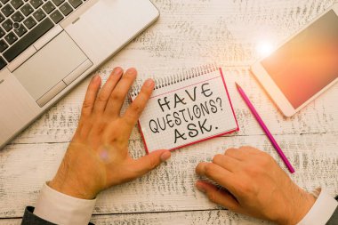Writing note showing Have Questionsquestion Ask. Business photo showcasing something that you say or write to ask a demonstrating Hand hold note paper near writing equipment and smartphone.