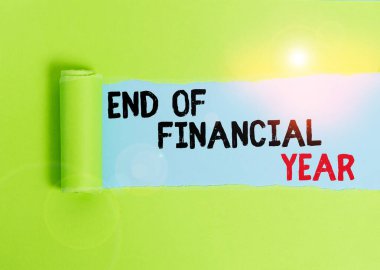 Text sign showing End Of Financial Year. Conceptual photo Revise and edit accounting sheets from previous year Cardboard which is torn in the middle placed above a plain table backdrop.
