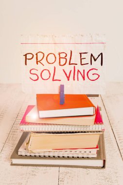Kavramsal el yazısı problem çözmeyi gösteriyor. Zorlu ya da karmaşık sorunlara çözüm bulunması için iş fotoğrafı metni süreci istiflenmiş kitaplar dizüstü not defteri renk hatırlatıcısı beyaz ahşap.