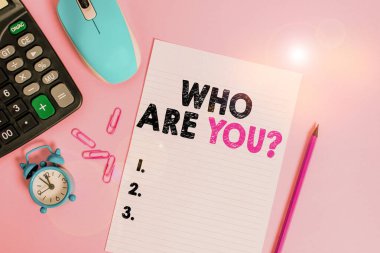Word writing text Who Are Youquestion. Business concept for someone asking your demonstratingal background or history Calculator clips alarm clock mouse sheet pencil colored background.