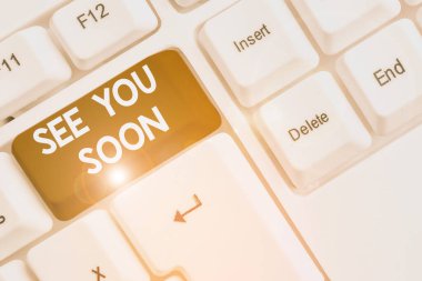 See You Soon 'u gösteren bir not yazıyorum. Biriyle vedalaşmak için kullanılan iş fotoğrafı sergisi ve yakında beyaz arkaplanının üzerinde nota kağıdıyla White Pc klavyesi ile tekrar buluşacak.