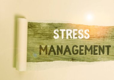 Handwriting text Stress Management. Concept meaning method of limiting stress and its effects by learning ways Cardboard which is torn in the middle placed above a wooden classic table. clipart