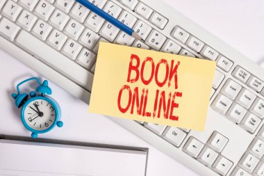 Kitap Online 'ı gösteren kavramsal el yazısı. Sadece İnternet 'te okunabilen iş fotoğrafı kitapçığı benzeri form pc klavye ve saat üzerinde boş not kağıdının üzerinde yatıyordu.