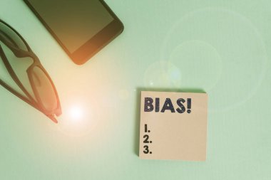 Text sign showing Bias. Conceptual photo inclination or prejudice for or against one demonstrating group Dark eyeglasses colored sticky note smartphone fashion pastel background. clipart