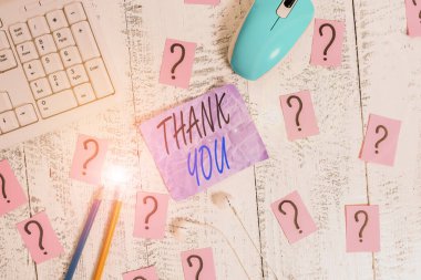 Teşekkür notu yazıyordum. Bir hediye veya hizmet kabul ederken kullanılan kibar bir ifadeyi gösteren iş fotoğrafı araçları ve ahşap masanın üzerine karalanmış kağıt.