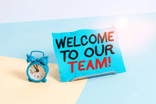 Writing note showing Welcome To Our Team. Business photo showcasing introducing another demonstrating to your team mates Alarm clock beside a Paper sheet placed on pastel backdrop. — Stock Photo, Image