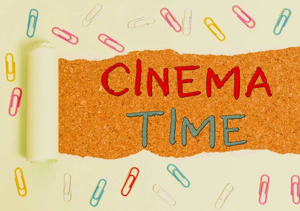 Handwriting text Cinema Time. Concept meaning which entertainment such showing movie scheduled to start Paper clip and torn cardboard placed above a wooden classic table backdrop.