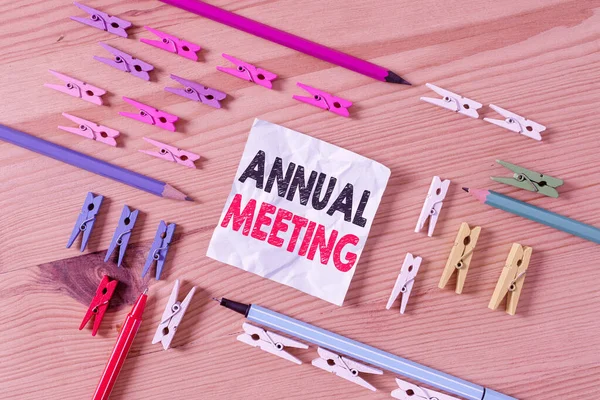 Word writing text Annual Meeting. Business concept for yearly meeting of the general membership of an organization Colored clothespin papers empty reminder wooden floor background office.
