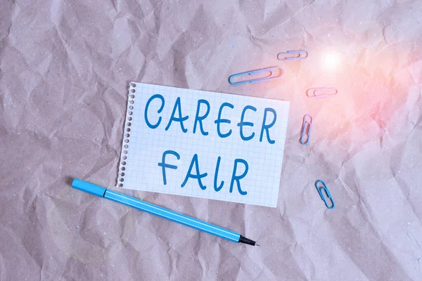 Writing note showing Career Fair. Business photo showcasing an event at which job seekers can meet possible employers Papercraft desk square spiral notebook office study supplies.