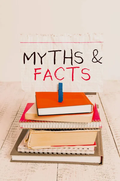 Conceptual hand writing showing Myths And Facts. Business photo text usually traditional story of ostensibly historical events pile stacked books notebook pin color reminder white wooden. — Stockfoto