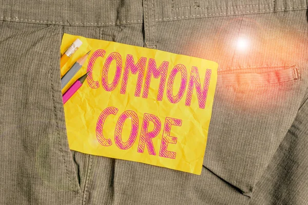 Szóírás szöveg Common Core. Üzleti koncepció a matematika és az angol nyelv egyetemi szabványaihoz Íróberendezések és sárga bankjegy papír a férfi munkaruha zsebében. — Stock Fotó