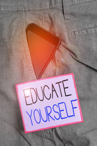 Text sign showing Educate Yourself. Conceptual photo prepare oneself or someone in a particular area or subject Smartphone device inside formal work trousers front pocket near note paper. — ストック写真