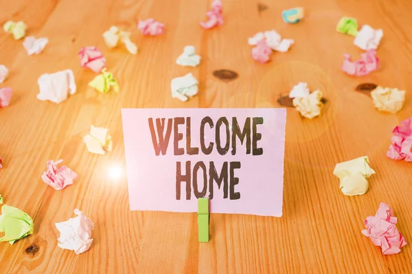 Writing note showing Welcome Home. Business photo showcasing a reception usually celebrate the return home of a demonstrating Colored crumpled papers wooden floor background clothespin. — Stok fotoğraf