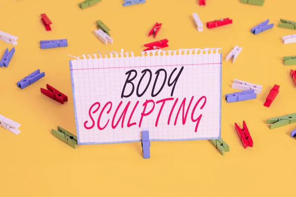 Writing note showing Body Sculpting. Business photo showcasing activity of increasing the body s is visible muscle tone Colored clothespin papers empty reminder yellow floor background office.