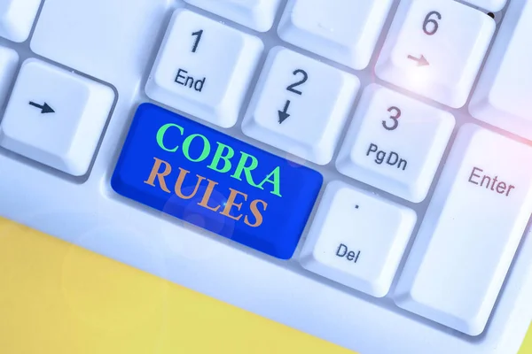 コブラ規則を示す概念的な手書き。仕事の損失の後の継続的なグループの健康保険の適用範囲を示すビジネス写真白い背景の上にノートPCのキーボード. — ストック写真