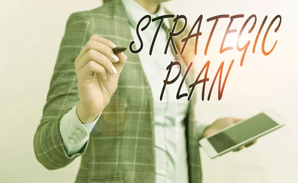 Handwriting text writing Strategic Plan. Concept meaning a systematic process of envisioning a desired future Business woman pointing in empty space with pen and mobile phone. — Stock Photo, Image