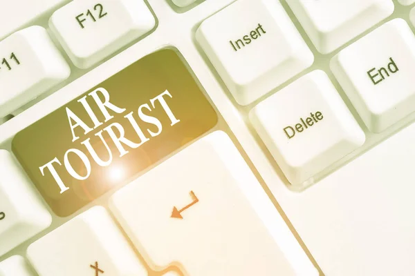 Text sign showing Air Tourist. Conceptual photo process of going from place to place by any flying object White pc keyboard with empty note paper above white background key copy space. — Stok fotoğraf