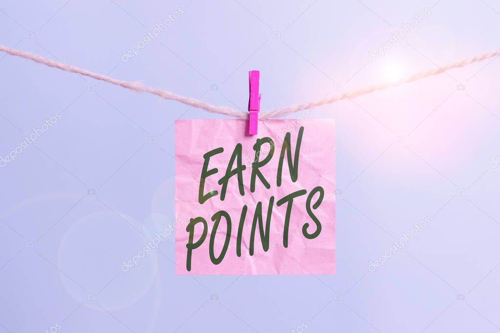 Text sign showing Earn Points. Conceptual photo to get praise or approval for something you have done or buy Clothesline clothespin rectangle shaped paper reminder white wood desk.