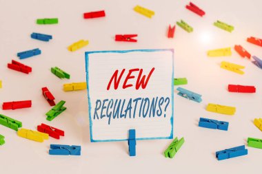 El yazısı metni Yeni Yönetmelik Sorusu. Kavram demek, hükümetin düzen denetimini bir şeyler yapıldığı şekilde sağlamış. Renkli çamaşır mandalı kağıtları boş hatırlatma beyaz zemin arka plan ofisi..