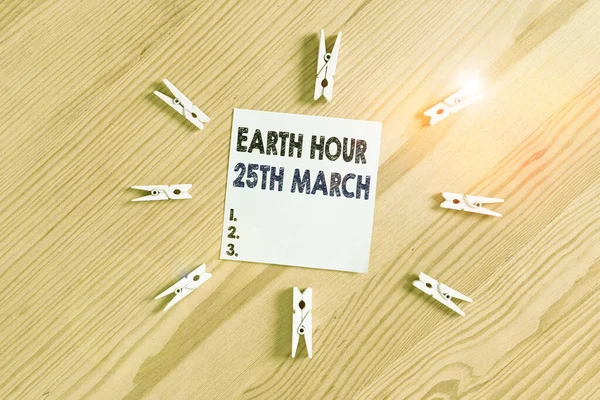 Слова до тексту Earth Hour 25 March. Бізнес-концепція прихильності символу до планети Організований Всесвітній фонд кольорового оздоблення документи порожнього нагадування дерев'яного фонового офісу підлоги. — стокове фото