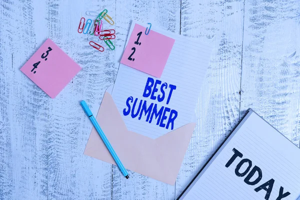 Woord schrijven tekst Beste zomer. Zakelijk concept voor het weer is warmer en analytische studenten krijgen een pauze van school Envelop vel papier plakkerige notities ballpoint notitieblok clips houten achtergrond. — Stockfoto