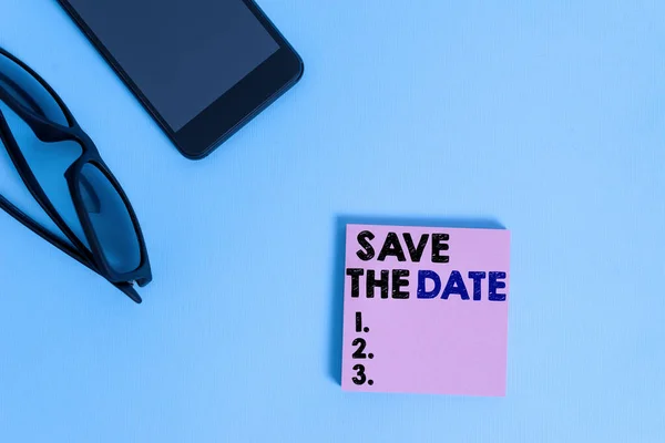 Text sign showing Save The Date question. Conceptual photo asking someone to remember specific day or time Dark eyeglasses colored sticky note smartphone fashion pastel background. — Stock Photo, Image