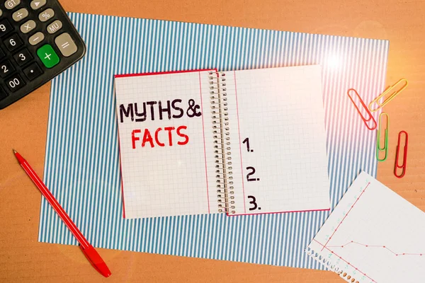 Text sign showing Myths And Facts. Conceptual photo usually traditional story of ostensibly historical events Striped paperboard notebook cardboard office study supplies chart paper. — Stock Photo, Image