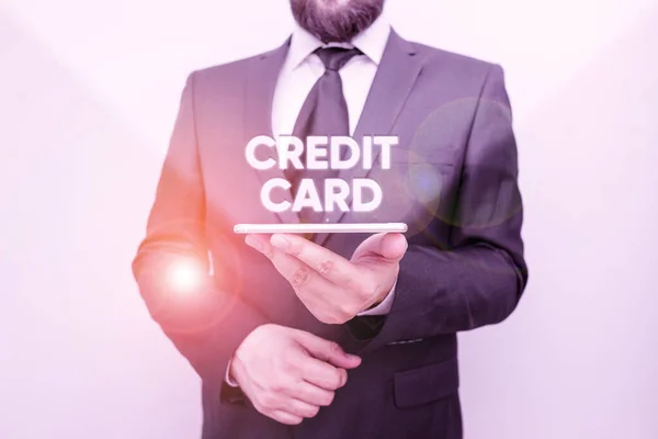 Word writing text Credit Card. Business concept for card that allows you to borrow money against a line of credit Male human wear formal work suit hold smart hi tech smartphone use one hand.