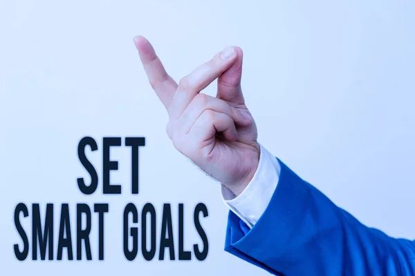 Handwriting text Set Smart Goals. Concept meaning giving criteria to guide in the setting of objectives Isolated hand pointing with finger. Business concept pointing finger.
