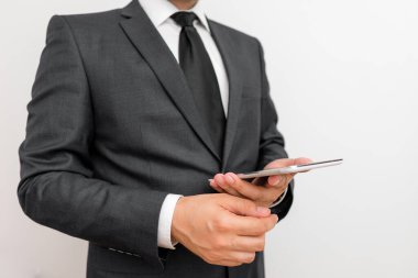 Sakallı bir erkek resmi iş kıyafetleri giyer yüksek teknoloji akıllı telefon cihazı taşır. İş elbisesi giymiş bir adam ve kravatlı küçük cep telefonlu bir adam tek elini kullanıyor.
