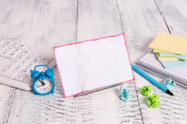 Bir klavye ve matematik kitabı arasında tampon telin üzerinde duran beyaz renkli bir not kağıdı. Kalın matematik sayfaları ile yazmak için bilgisayar ekipmanlarının yanında duran eski notasyon kağıdı