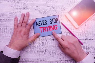 Denemeyi Asla Durdurmayan 'ı gösteren bir not yazıyorum. İş fotoğrafı gösteriminden vazgeçmeyin Yeniden Denemeye Devam edin Yazma ekipmanı ve akıllı telefonun yanında not kağıdı tutun.