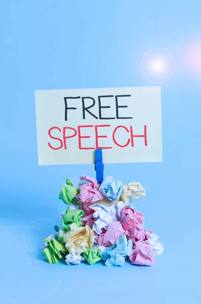 Word writing text Free Speech. Business concept for the right of showing to express their opinions publicly Reminder pile colored crumpled paper clothespin reminder blue background.