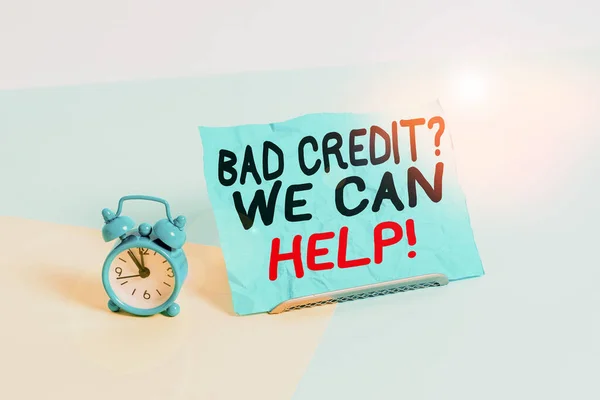 Writing note showing Bad Credit Question We Can Help. Business photo showcasing offering help after going for loan then rejected Alarm clock beside a Paper sheet placed on pastel backdrop.