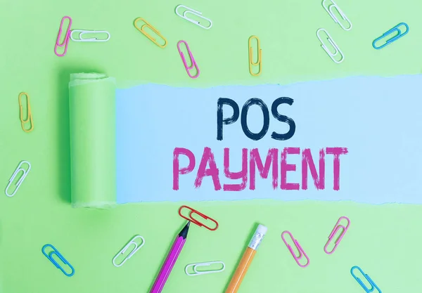 Word writing text Pos Payment. Business concept for customer tenders payment in exchange for goods and services Stationary and torn cardboard placed above a plain pastel table backdrop.