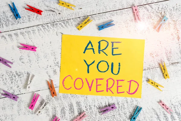 Scrittura concettuale a mano che mostra Are You Covered. Testo della foto aziendale Chiedendo su come i farmaci sono coperti dal vostro piano Stendibiancheria colorato rettangolo a forma di carta sfondo blu . — Foto Stock