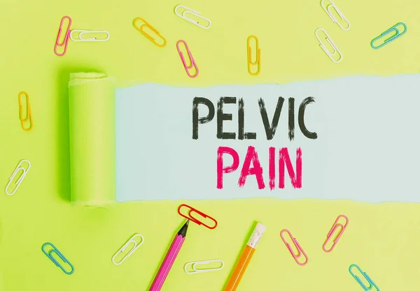 Word writing text Pelvic Pain. Business concept for Pain perceived in the area of the lower part of the abdomen Stationary and torn cardboard placed above a plain pastel table backdrop.