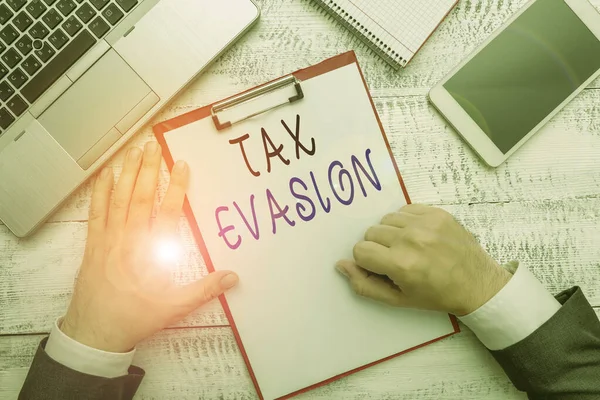Word writing text Tax Evasion. Business concept for the failure to pay or the deliberate underpayment of taxes Hand hold writing equipment tool near modern high technology laptop device. — Stock Photo, Image