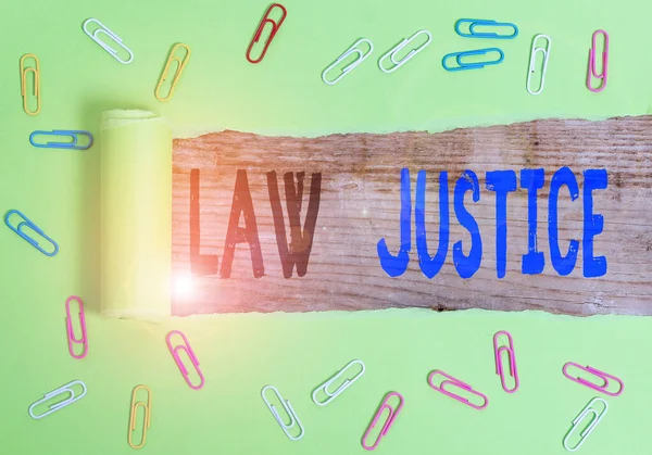 Text sign showing Law Justice. Conceptual photo a scheme or system of law in which every demonstrating receives Paper clip and torn cardboard placed above a wooden classic table backdrop.