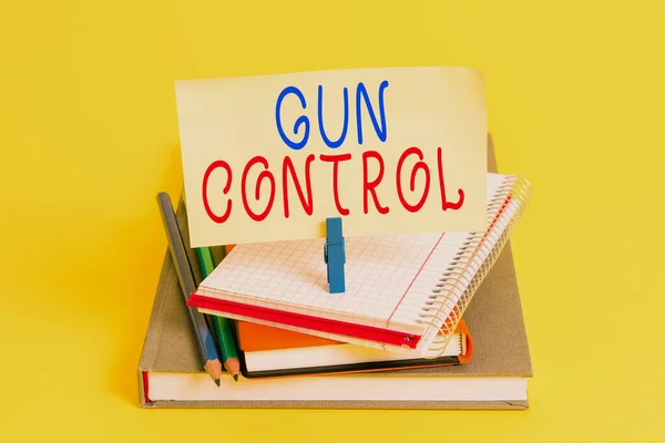 Conceptual hand writing showing Gun Control. Business photo showcasing legal measure intended to restrict the possession of guns Book pencil rectangle shaped reminder notebook clothespins.