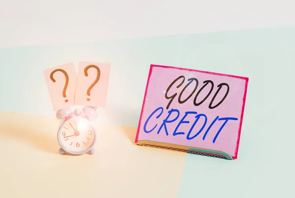 Word writing text Good Credit. Business concept for borrower has a relatively high credit score and safe credit risk Mini size alarm clock beside a Paper sheet placed tilted on pastel backdrop.
