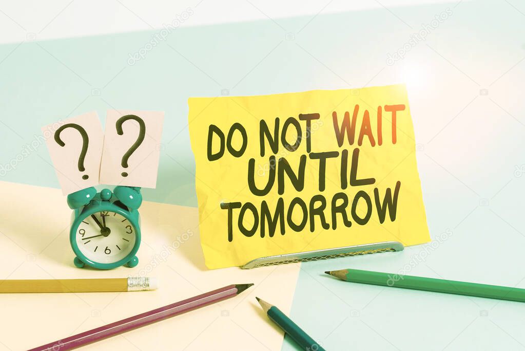 Text sign showing Do Not Wait Until Tomorrow. Conceptual photo needed to do it right away Urgent Better do now Mini size alarm clock beside stationary placed tilted on pastel backdrop.
