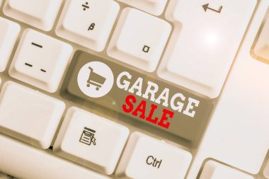 Conceptual hand writing showing Garage Sale. Business photo showcasing sale of miscellaneous household goods often held in the garage White pc keyboard with note paper above the white background.