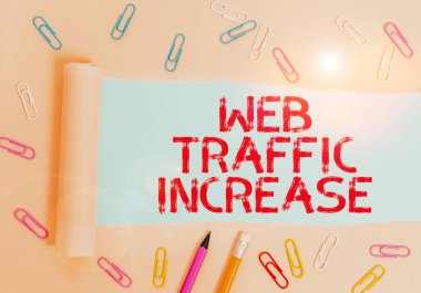 Web Trafiğinin Arttığını gösteren bir not yazıyorum. İş fotoğraflarında Ziyaretçileri Bir Web sitesine Genişletiyorum Sabit ve yırtık kartonlar Sade pastel masa arkaplanının üzerine yerleştirilmiş.