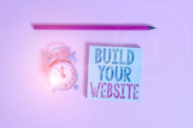 Kelime yazma metni Web sitenizi oluşturur. Ticari bir Metal klasik alarm saatini pazarlamak için bir ekommerce sistemi kurmak için iş konsepti boş bir not defteri işaretleyicisi renkli arkaplan.