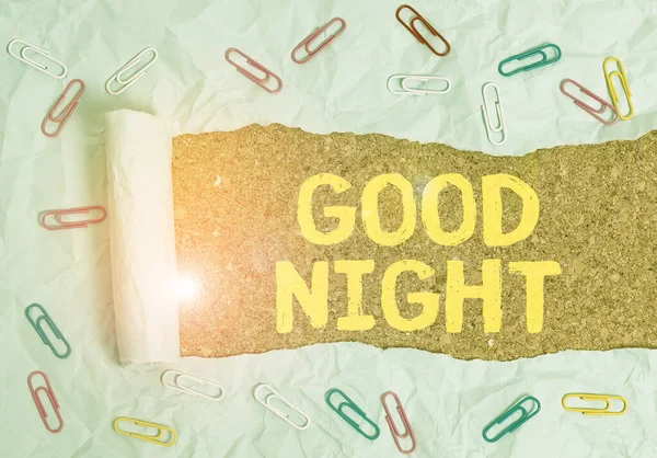 Text sign showing Good Night. Conceptual photo expressing good wishes on parting at night or before going to bed Paper clip and torn cardboard placed above a wooden classic table backdrop.